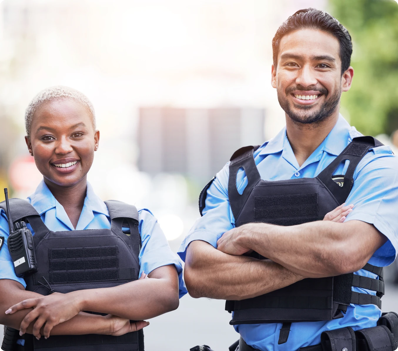 Diverse police duo posing confidently outside.