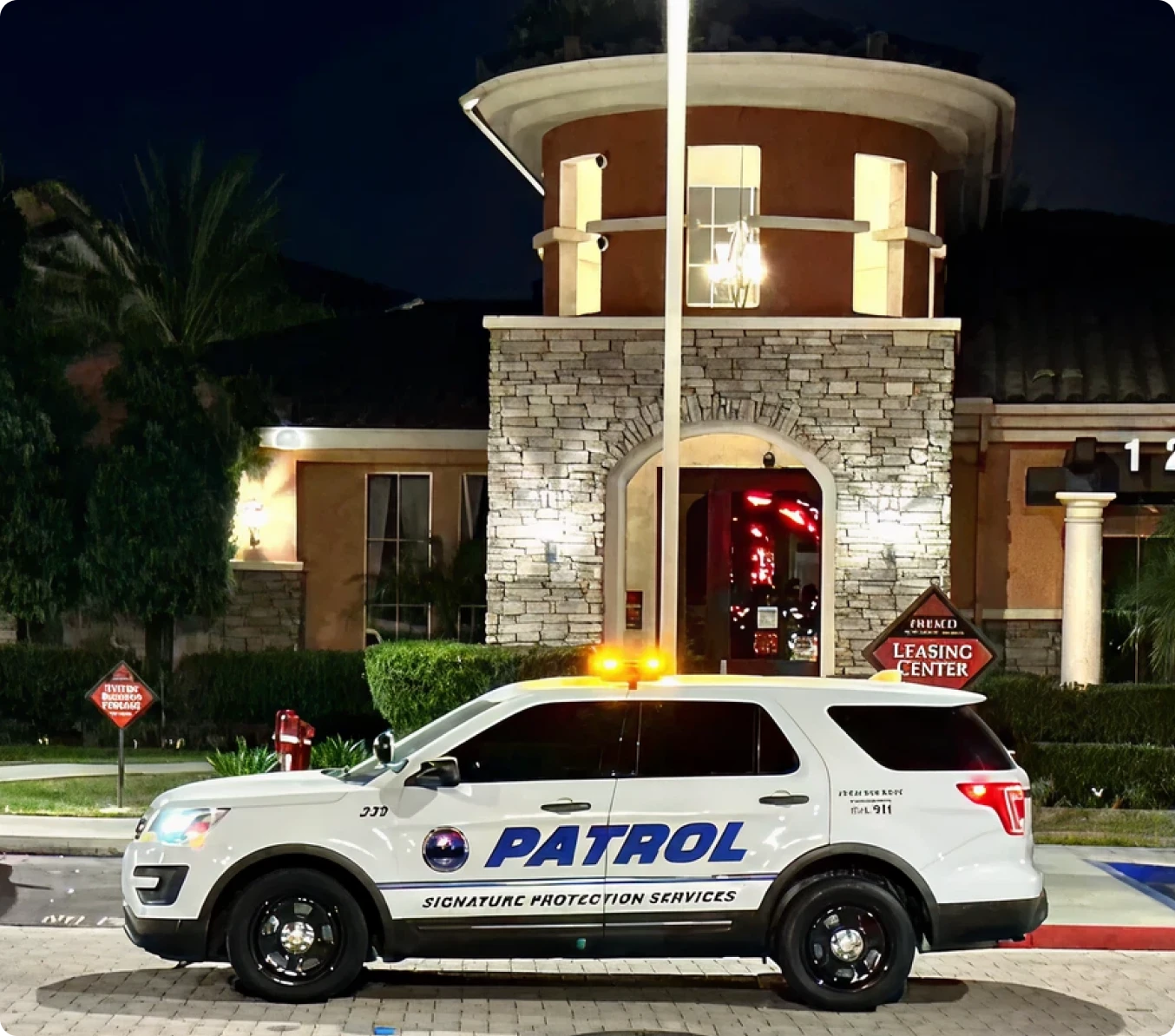 Security patrol vehicle outside building at night.